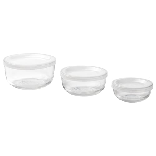 Three clear glass meal prep containers of varying sizes, with transparent lids, neatly stacked for storage.