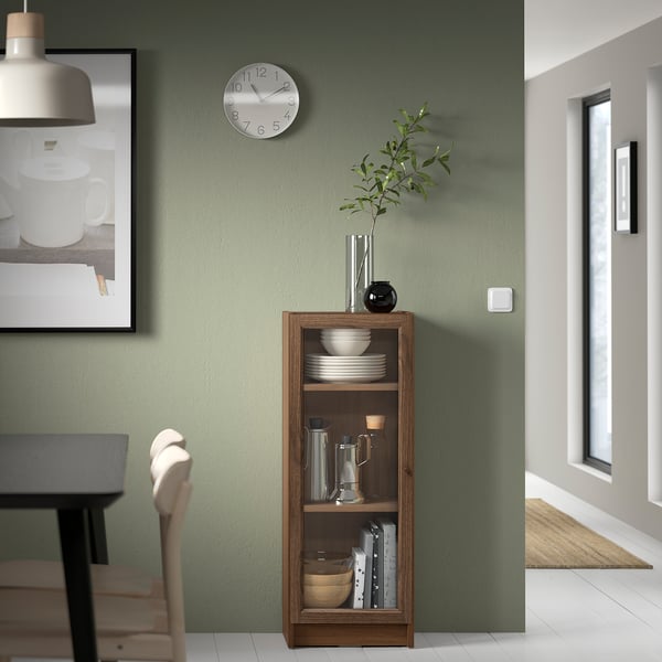Modern dining room with BILLY bookshelf, clock, and hanging light.
