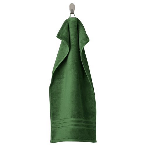 Green organic cotton towel with textured border hangs neatly on a hook.