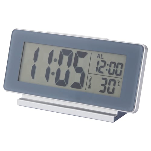 Digital clock, grey, rectangular, large numbers, shows time, alarm, and temperature.