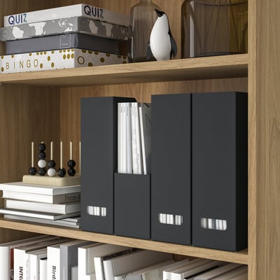 Two grey vertical magazine holders standing side by side made from recycled paperboard, featuring cut-out handles at the top end for easy access.