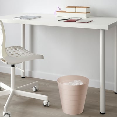 White desk with laptop and pink rubbish bin.