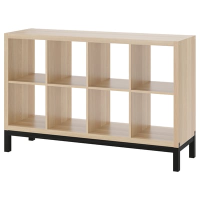 Ikea KALLAX light wood shelf unit with black underframe, rectangular shape, open compartments.