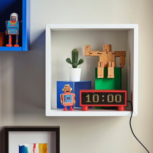 White shelf with KORTLINJE clock, cactus, wooden robot, retro toy.