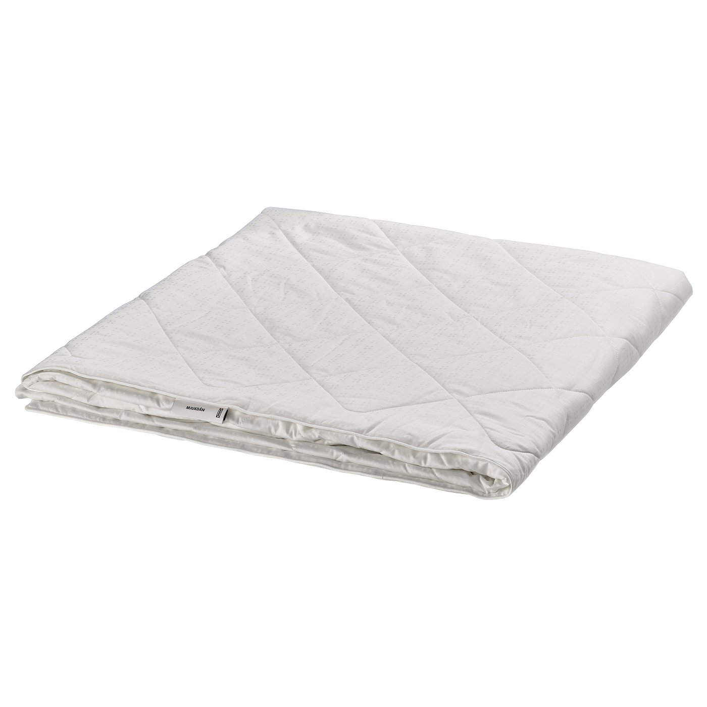 Folded white silk duvet by IKEA, soft cotton exterior, luxurious silk filling.