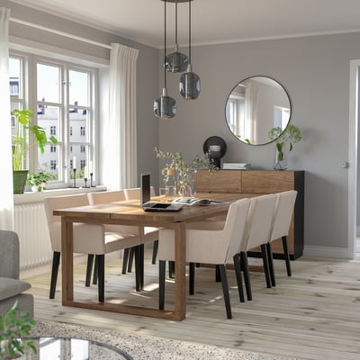 Modern dining set with oak table, beige chairs, hanging lights, grey walls, large window, mirror, and wooden floor.