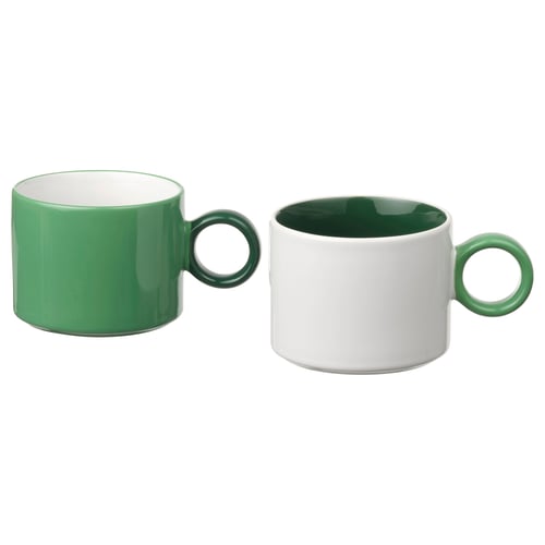 Two green and white mugs with contrasting colour schemes, featuring simple, functional design and stoneware material.