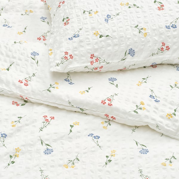 Elegant white duvet cover with colourful floral prints, showcasing high-quality fabric and intricate seersucker texture.