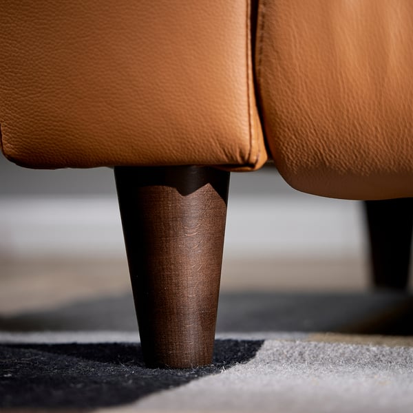 Close-up of tan leather recliner leg, showcasing sleek wood texture and sturdy design.
