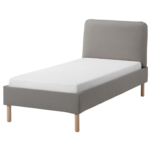 A grey upholstered bed frame with a sloped headboard, wooden legs, and a white mattress. Modern and inviting design.