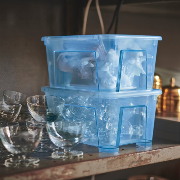 Two blue SAMLA plastic organisers, stacked with small glasses inside. Transparent, rectangular, and sturdy, ideal for storing small items.