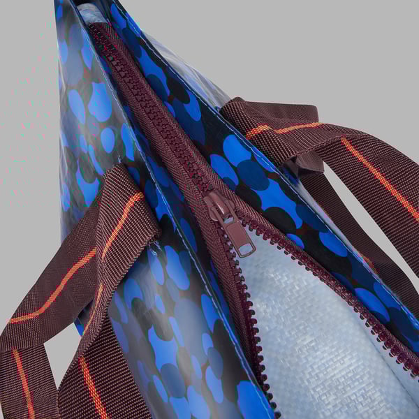 Colourful reusable bag with sturdy straps, durable zip, and translucent body for easy visibility.