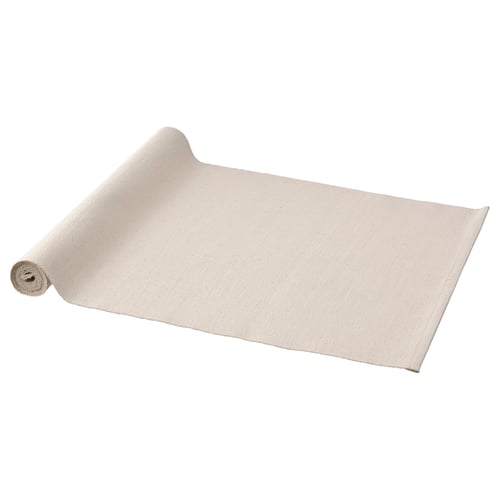 A rolled-up white cotton table runner named SVARTSENAP. Its plain and rectangular.