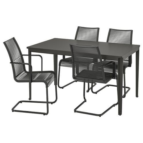 Black outdoor table set with four wicker chairs. Modern design, metal frame.