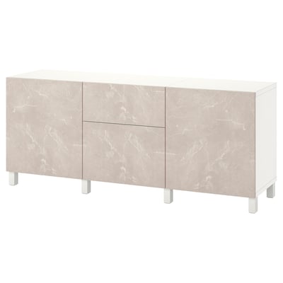 Omara ikea BESTÅ v beli barvi z bež marmornimi vrati, podprta z belimi nogami.