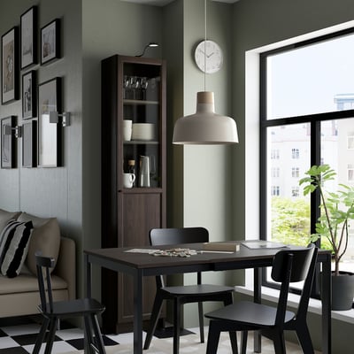 Udobna jedilnica s knjižno omarico, mizo, svetilko, uro in kavčem.