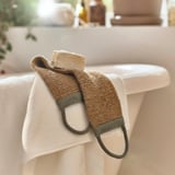 Rjavi pas iz jute visi na beli brisači v bližini umivalnika.