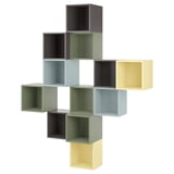 Regal ikea EKET s kockami v zeleni, modri, rumeni in črni barvi. Sodobna, geometrijska zasnova.