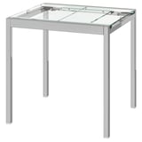 Jedilna miza IKEA GLIVARP s prozorno stekleno ploščo in kromiranimi nogami. Sodoben dizajn je eleganten in varčuje s prostorom.