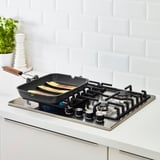 Bučke na črni grill ponvi kuhanje na štedilniku.