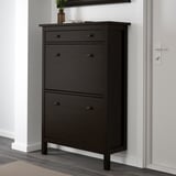 Črna omarica za čevlje HEMNES ustreza 14 parom, prezračevanim predelkom, ki jih je mogoče namestiti na steno.
