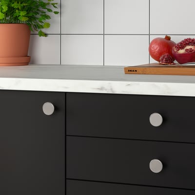 Kuhinjski pult z granatnimi jabolki in rastlino, sodobni črni predali s kovinskimi gumbi KALERUM.