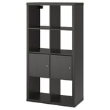 Črni regal KALLAX znamke ikea, združuje odprto in zaprto shranjevanje, eleganten in funkcionalen.
