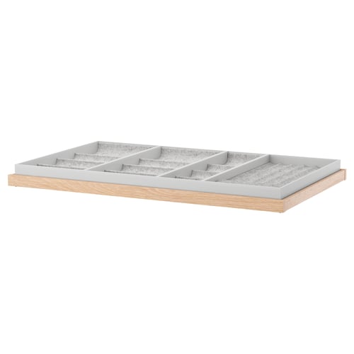 Sivi pladenj IKEA KOMPLEMENT s predali za nakit na beli podlagi.