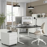 Sodobna pisarniška postavitev z belo stoječo mizo MITTZON s črnim vrhom, ergonomskim stolom, dvojnimi obesnimi lučmi in monitorjem. Visoka, elegantna oblika.