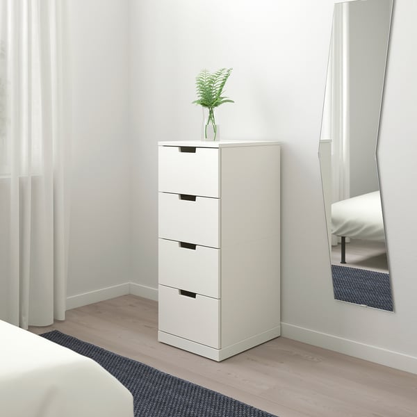NORDLI skrinjo z ogledalom in rastlino v svetli sobi.