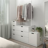 NORDLI bela komoda, elegantna in moderna, z ograjo za oblačila. Visi v bližini postelje, dobro se prilega v sobo.