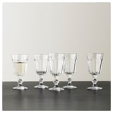 Pet prozornih kozarcev za vino POKAL, vsak klasičnega, elegantnega dizajna, lepo razporejenih na temni površini.