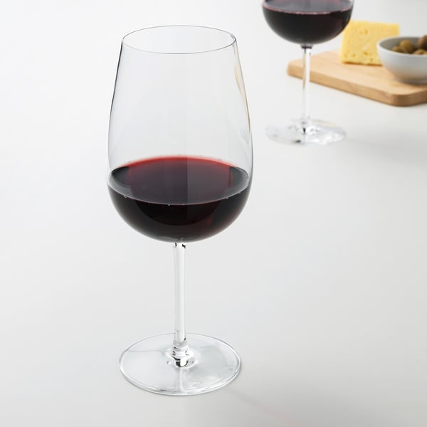 Dva kozarca za vino z rdečim vinom, sir, oljke na leseni deski.