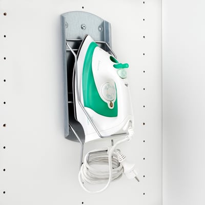 Stensko držalo za železo ohranja železo varno in kabel organiziran, zaradi česar je omara urejena.