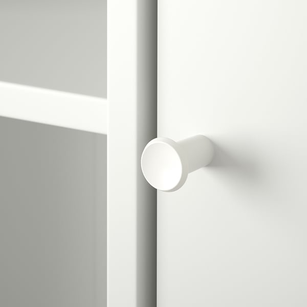 Detailný záber na bielu kľučku dverí, hladkú a modernú, pripevnenú k čistým dverám. Rukoväť je valcová s bezšvovým povrchom.