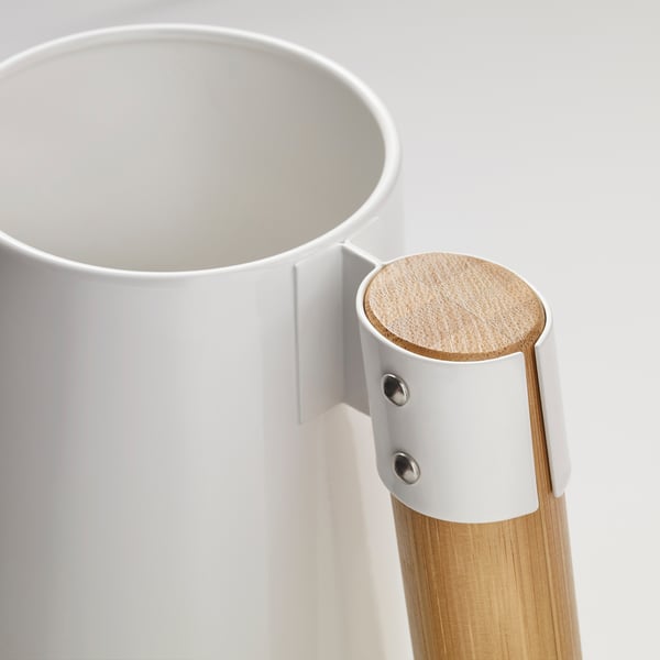 Štýlová kanvica s bambusovou rukoväťou a bielym kovovým telom, určená na vystavenie.