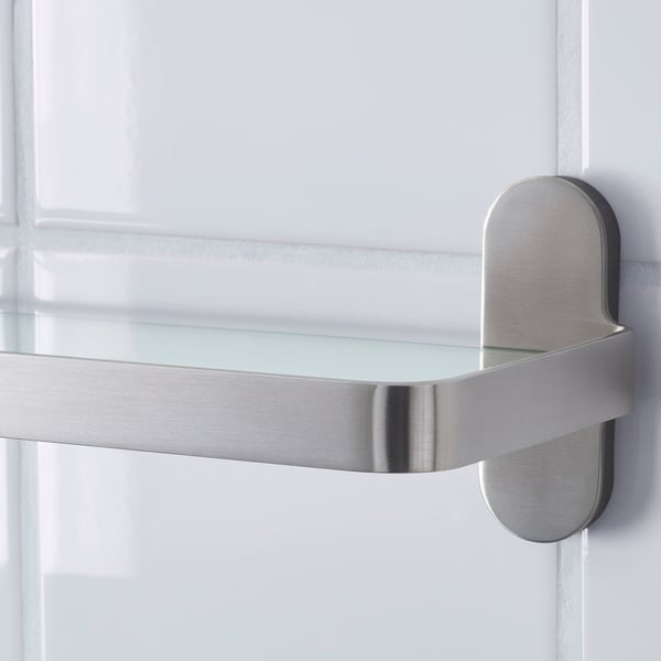Moderná polica z nehrdzavejúcej ocele s čírym skleneným panelom, pripevnená k hladkému povrchu.