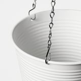 Detailný záber bieleho závesného kvetináča s kovovým reťazovým háčikom na zavesenie.