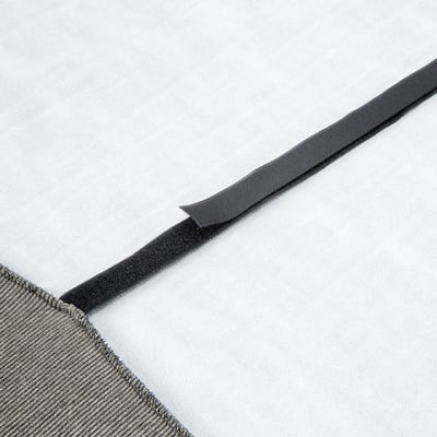 Detailný záber úhľadne zloženého sivého elastického remienka z kvalitnej priliehavej plachty, zameraný na jeho odolnú, textúrovanú povrchovú úpravu.