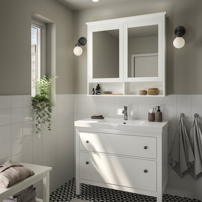 Moderná biela kúpeľňa s umývadlom, zrkadlom a uterákmi HEMNES.
