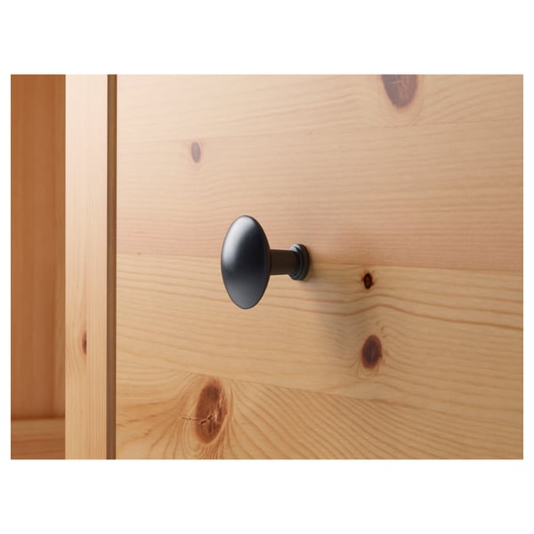 Detailný záber dreveného nábytku s modernou rukoväťou, zdôrazňujúci štruktúru zrna a kvalitné remeselné spracovanie.