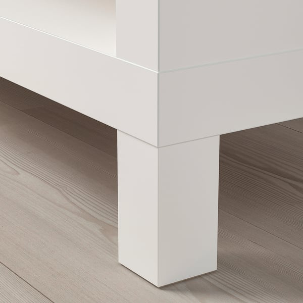 Biely moderný televízny stolík na drevenej podlahe. Elegantný, minimalistický dizajn.