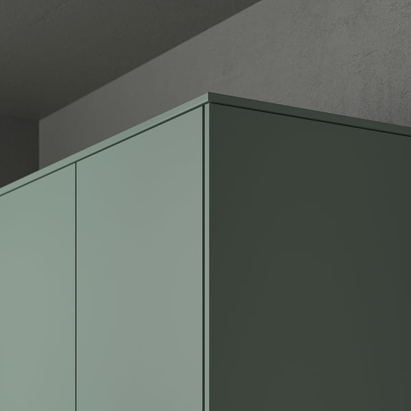 Moderná kuchynská skrinka zblízka s matnými šedozelenými panelmi NICKEBO a ozdobnými lištami skrývajúcimi osvetľovacie jednotky.