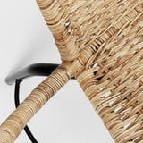 Tkaný ratanový detail stoličky, prírodná farba s čiernym kovovým rámom, odborne spracovaný.