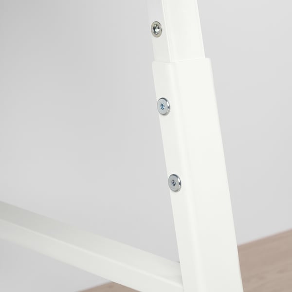 Detailný záber na bielu kovovú nohu stola s tromi viditeľnými skrutkami, ktoré ju zaisťujú, predvádzajúc robustnú konštrukciu.