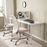 Preplážka na stôl SKÅDIS do domácej kancelárie so stoličkami, notebookom, lampou, slúchadlami, nožnicami, perforovanou doskou a hodinami.