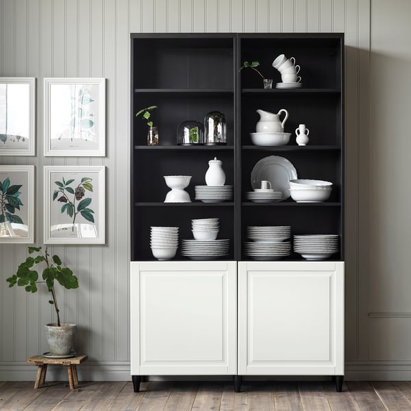 Čiernobiely úložný priestor SMEVIKEN s riadom, vázami a rastlinami. Moderný, čistý dizajn.