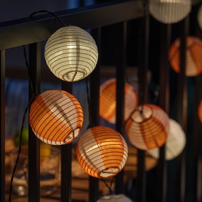 Sférické solárne lampáše v noci hrejivo svietia z balkóna alebo terasy.