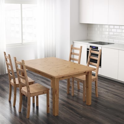 Drevený jedálenský stôl STORNÄS so stoličkami, borovica, 4-6 miest na sedenie, rozkladaci, tmavá podlaha, biele skrinky.