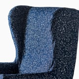 Tmavomodré kreslo so zložitým kvetinovým vzorom, elegantným dizajnom, vysokým operadlom, detailným poťahom.